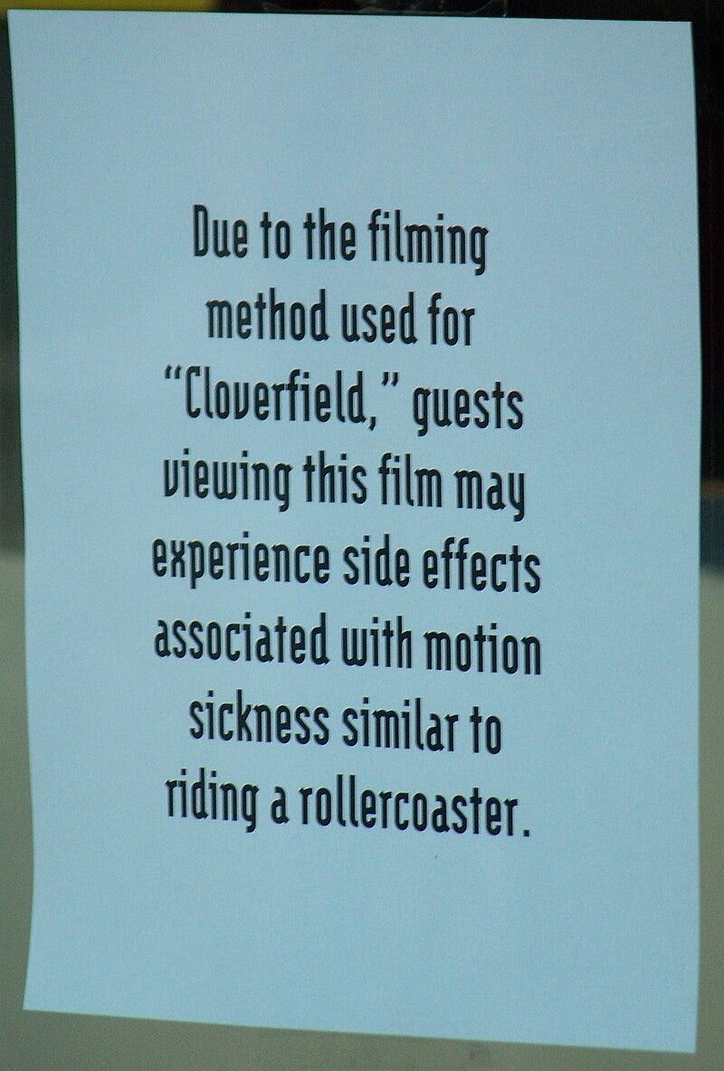 A posted, printed piece of paper, warning viewers that the movie Cloverfield may induce motion sickness due to how it is filmed.