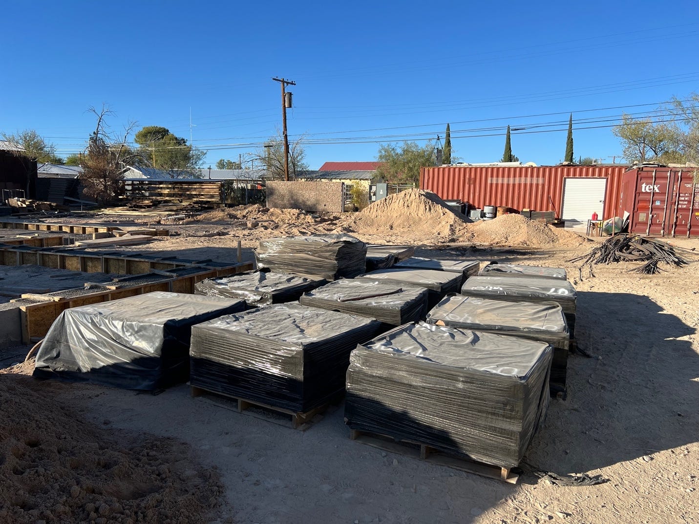 A pile of pallets with plastic wrap around them

Description automatically generated