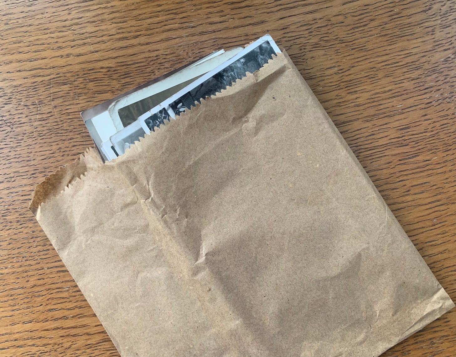 Photo of a brown paper bag with the edges of photographs poking out.