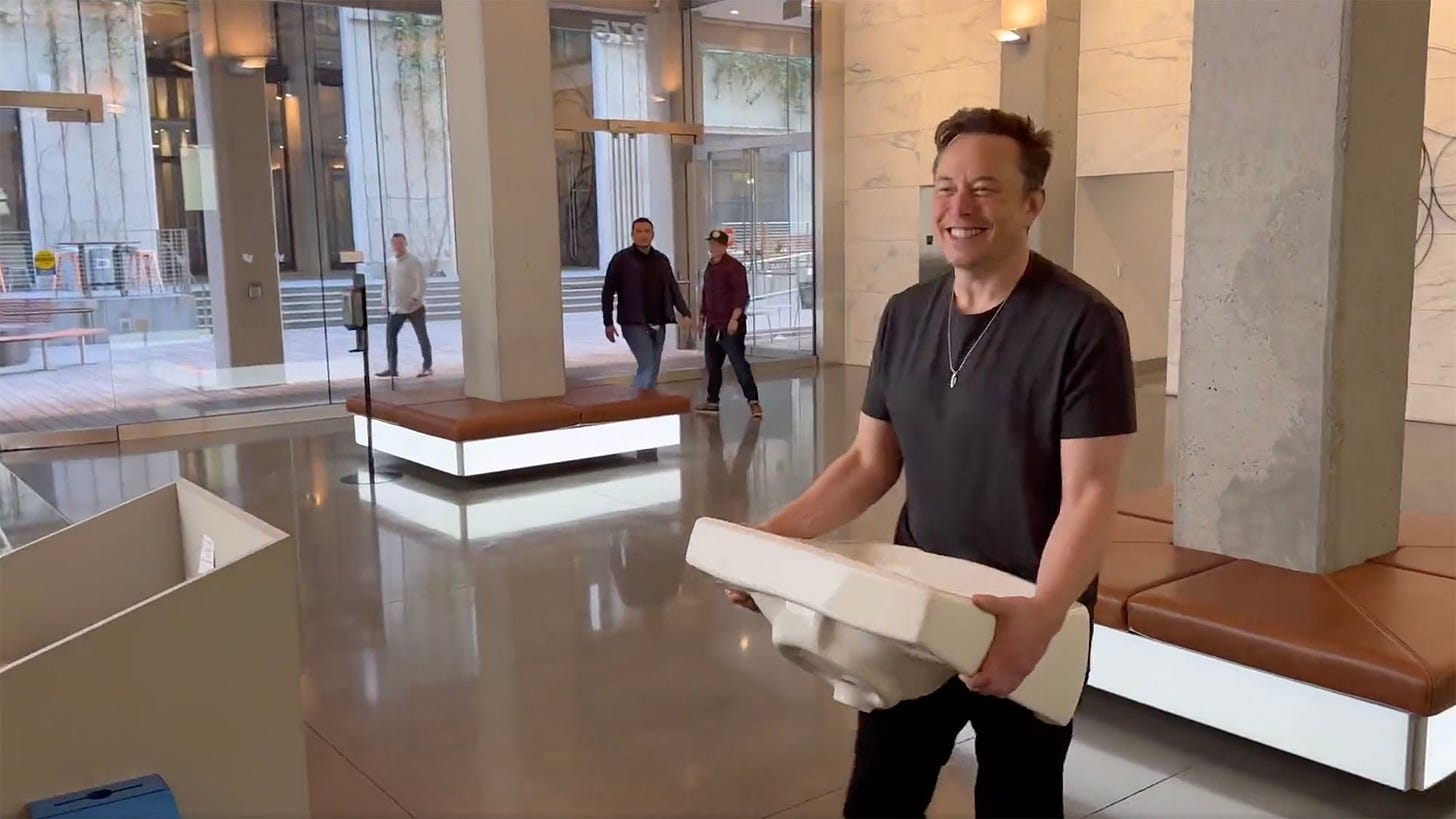 Elon Musk carries a sink into Twitter headquarters with a giant shit-eating grin on his face.