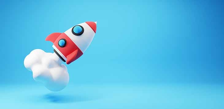 Photo of cartoon-style toy space rocket on a blue sky background.