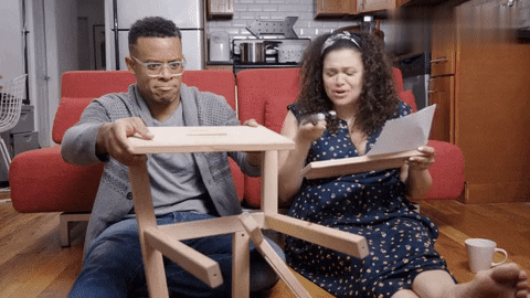 A Gif of two friends failing miserably at assembling the IKEA furniture