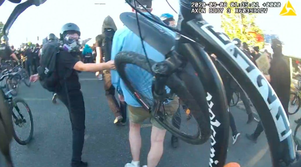 Screenshot from BWV depicting a bike's front tire being used to "push" a protestor.