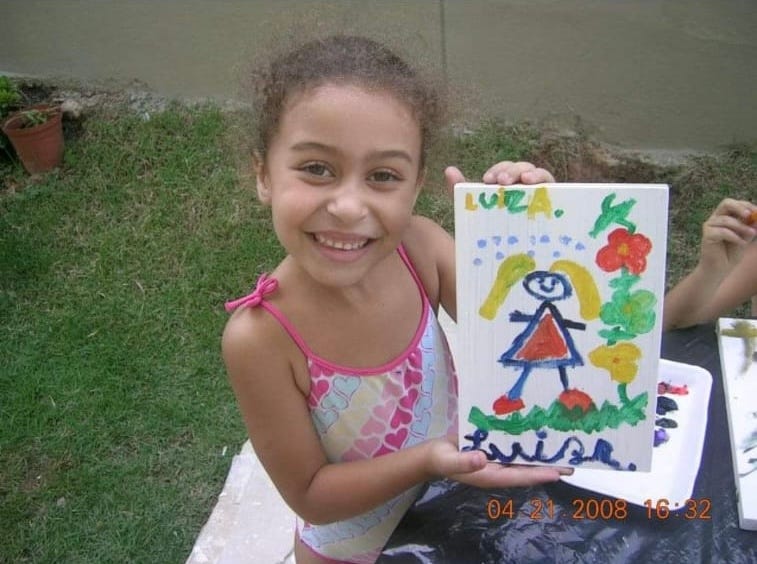 Criança segurando pintura infantil