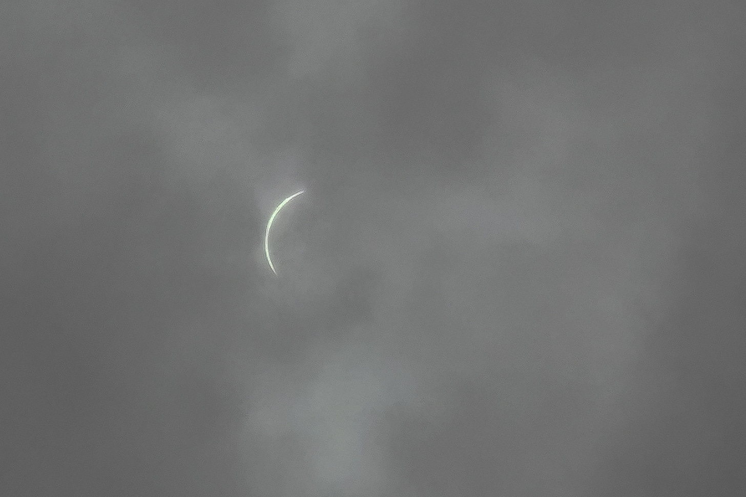 The Total Eclipse of the Sun behind clouds with only one side of the eclipse showing