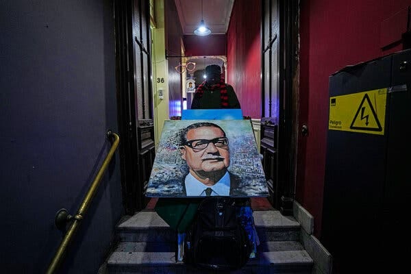 A painting of Salvador Allende being carried up a set of stairs on a dolly.