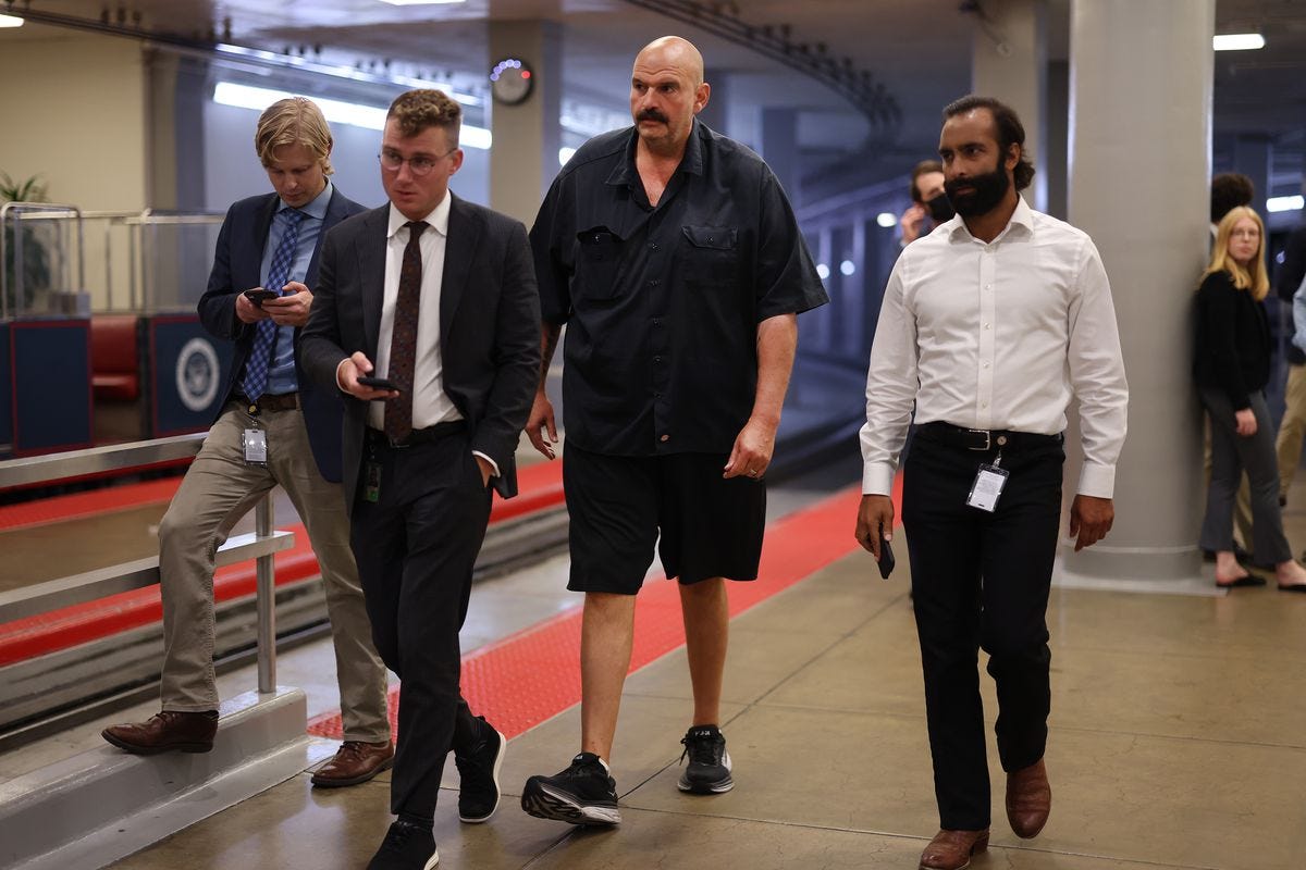 John Fetterman walks in shorts and sneakers.