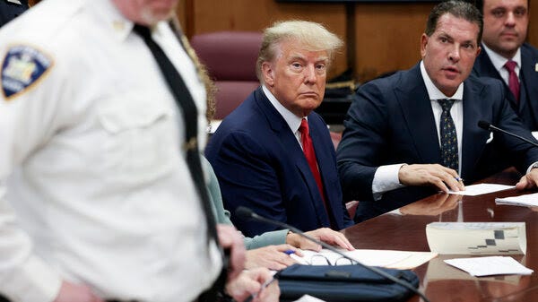 Former President Donald Trump sits in the courtroom with his attorneys Joe Tacopina and Boris Epshteyn (right) during his arraignment at the Manhattan Criminal Court on April 4 in New York City.