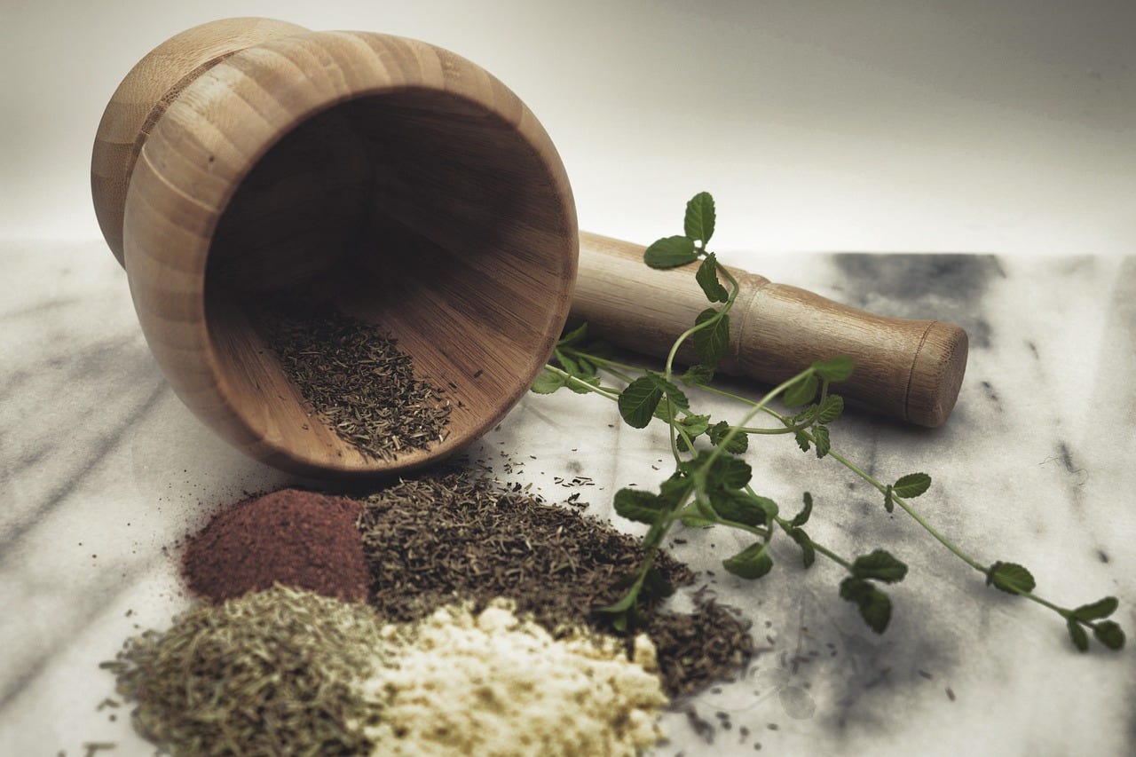 Pestle and mortar with ground and fresh herbs