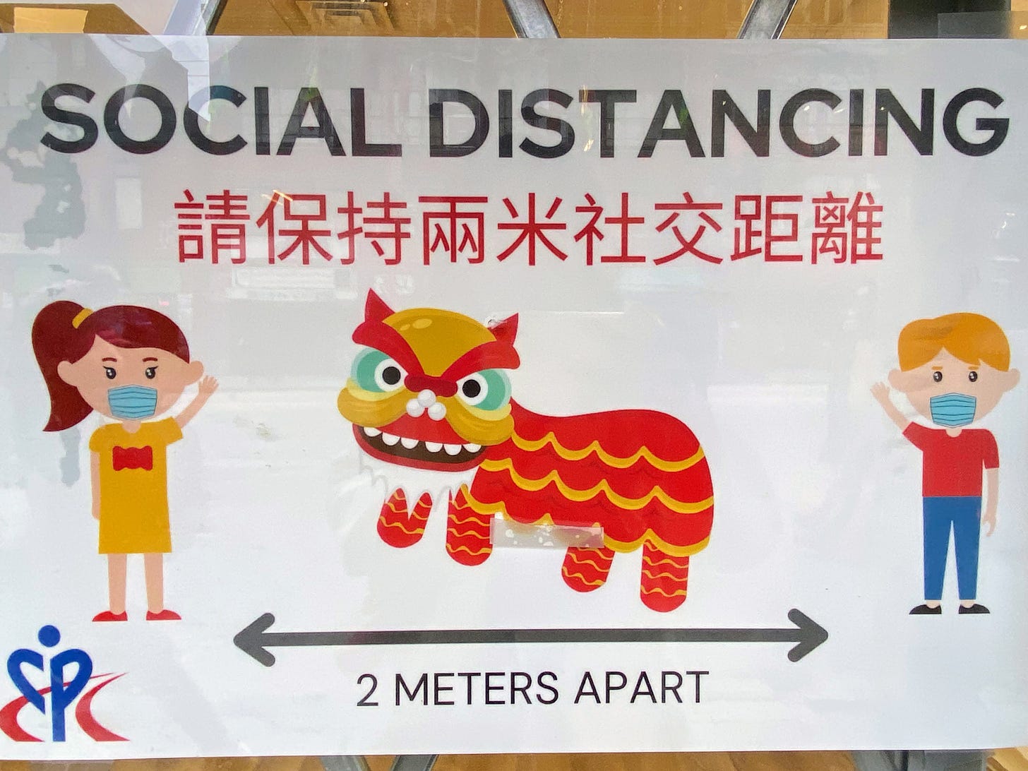 social distancing sign with lion dancer between two people