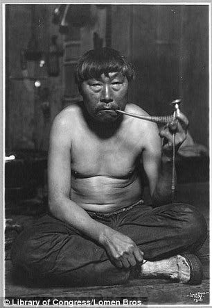 An Eskimo smokes a pipe