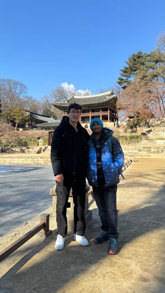 Two men standing next to each other

Description automatically generated