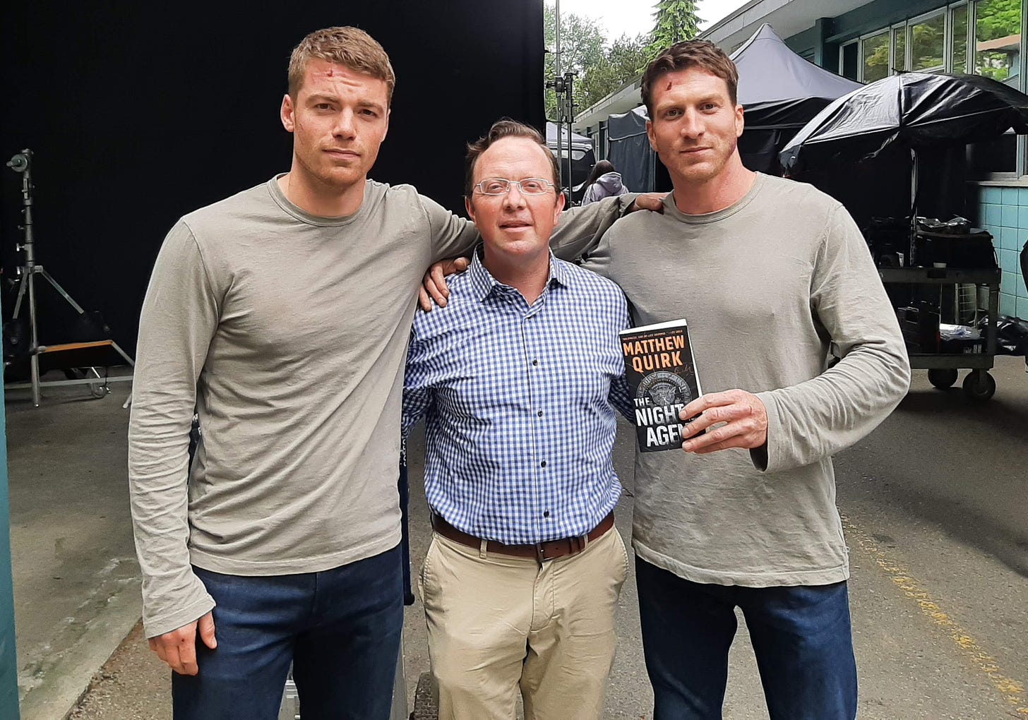 From left are actor Gabriel Basso, author Matthew Quirk, and stuntman Matthew Mylrea on the Vancouver set of “The Night Agent.” The book was a 2019 bestseller by Quirk and a smash hit on Netflix in 2023. Quirk is the featured speaker at the Dove Library in Carlsbad on Saturday. Courtesy photo