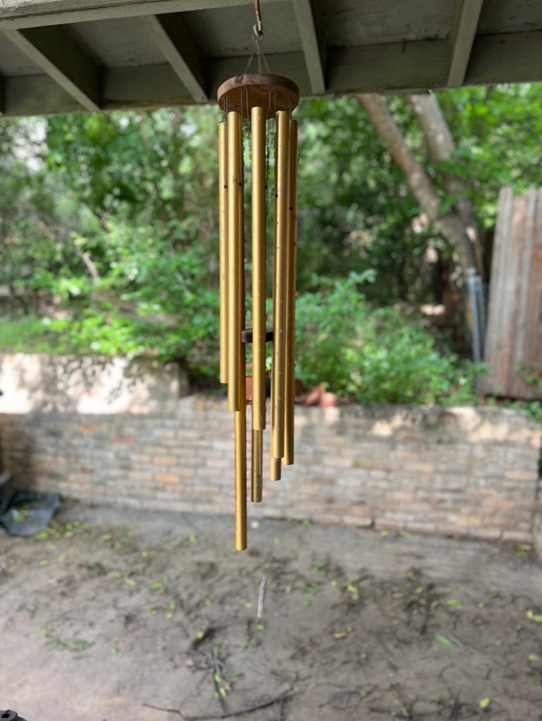 A wind chime from a roof

Description automatically generated