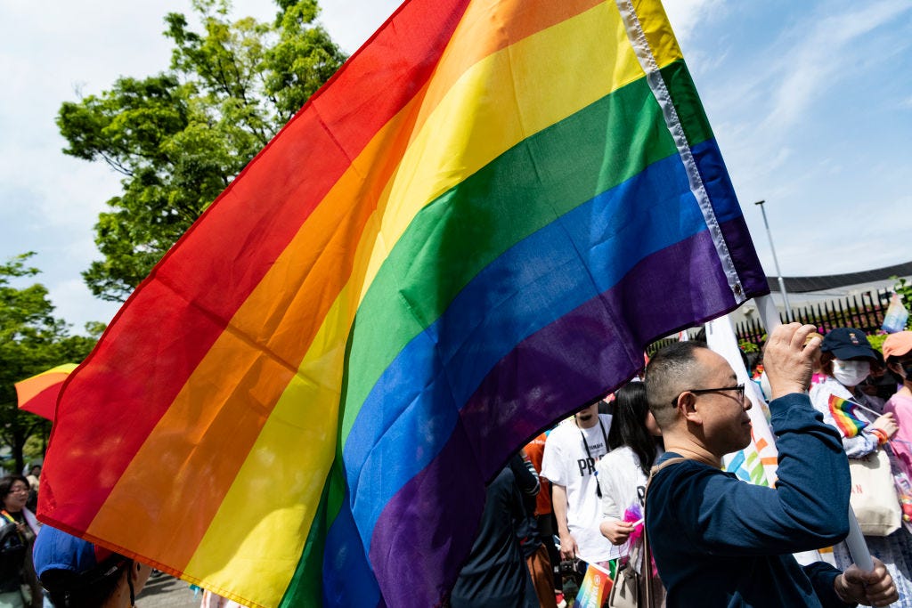 A participate raises a rainbow flag during the pride parade in Tokyo, April 23, 2023. (Yusuke Harada—NurPhoto/Getty Images)