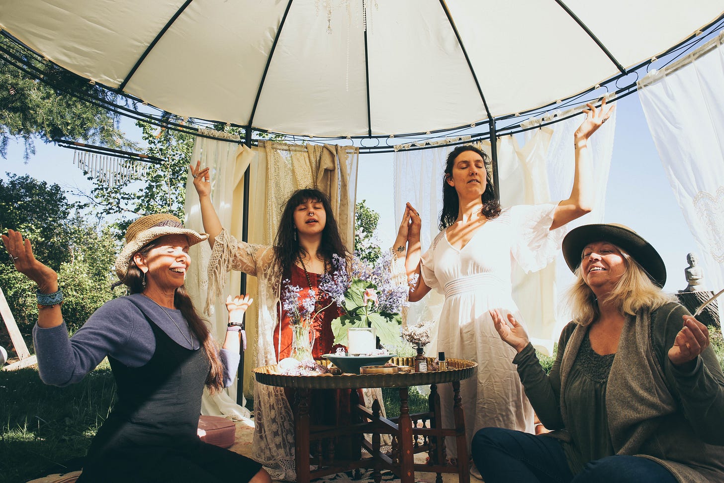 Mermaid temple ceremony with 4 women raising hands