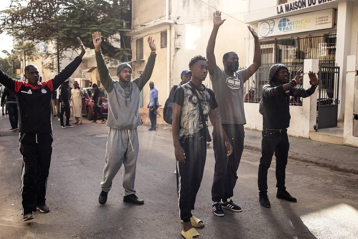 Protesters raise their hands outside the National Assembly in Senegal.
