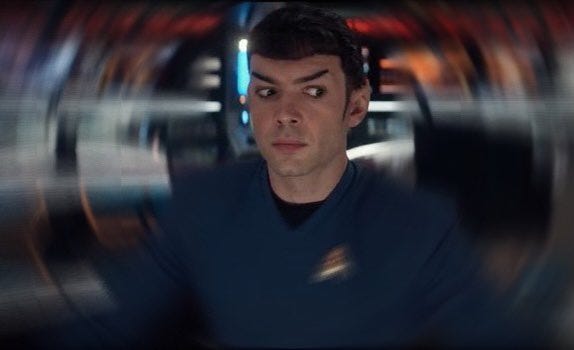 Strange New Worlds-era Spock, his eyes looking nervously to the side as he sits in the captain's chair. The background has been blurred in a whirlpool-like way to make it resemble the Mr. Krabs meme.