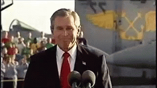 a gif of george bush on the aircraft carrier giving a thumbs up with the "mission accomplished" banner on display early in the Iraq war