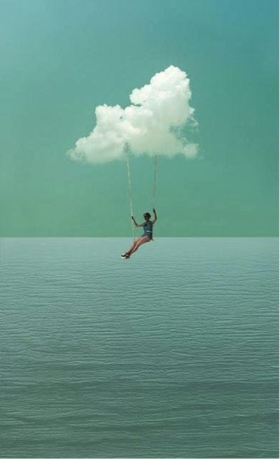 This may contain: a person on a swing suspended from a cloud above the water with a sky background