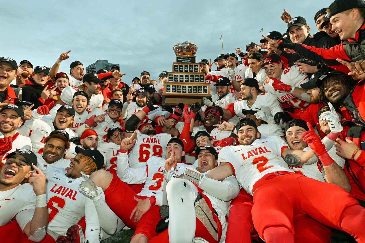 Laval Rouge et Or football players take a team photo gathered around the Vanier Cup