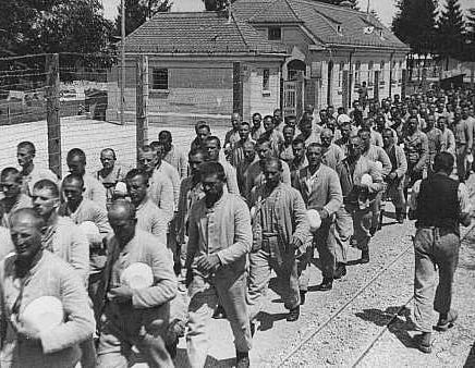 Prisoners carrying bowls in the Dachau concentration camp.