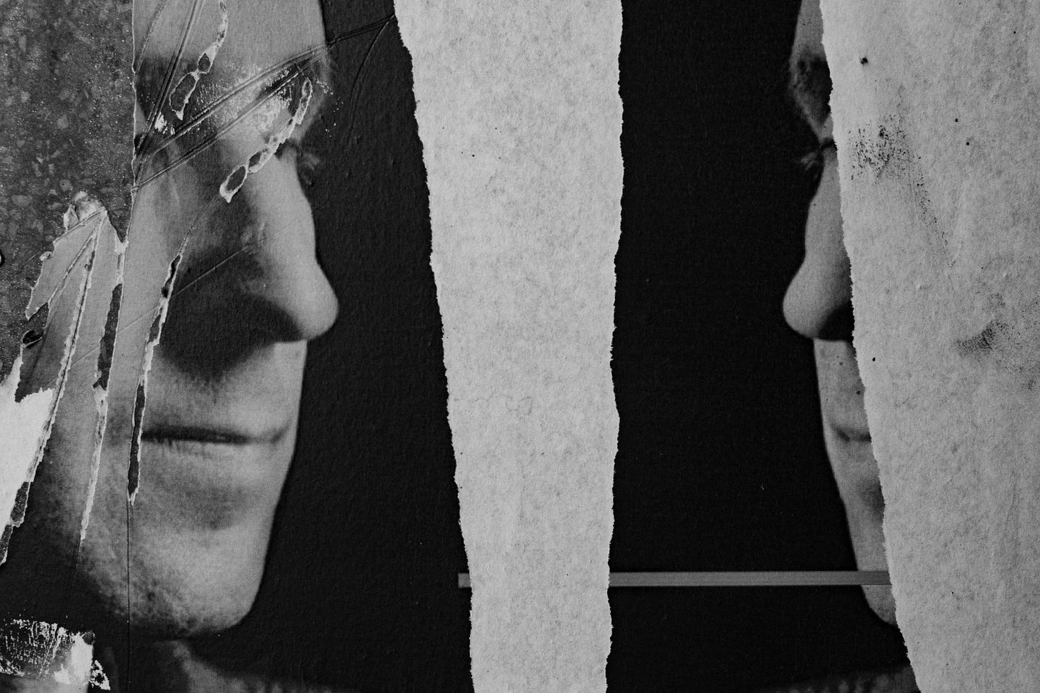 A torn poster depicting two identical faces in confrontation.