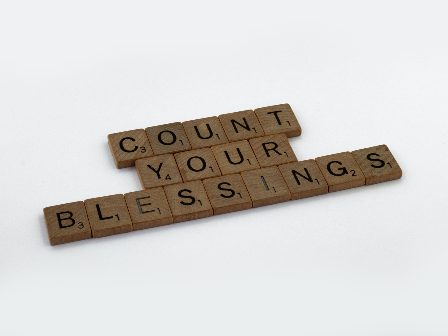 Scrabble tiles spelling the phrase "Count Your Blessings"