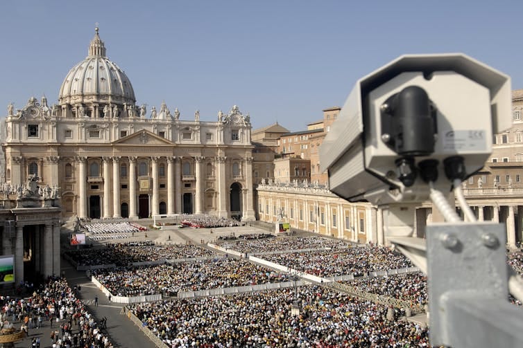 Surveillance camera overlooking a large crowd of people in front of a historical building. Surveillance camera overlooking a large crowd of people in front of a historical building.