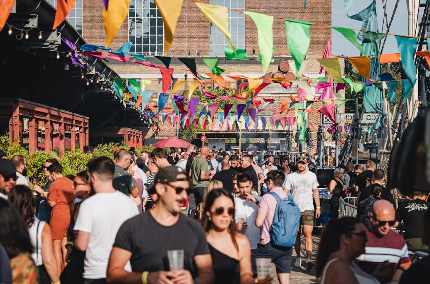 Crowds beneath colourful bunting outside