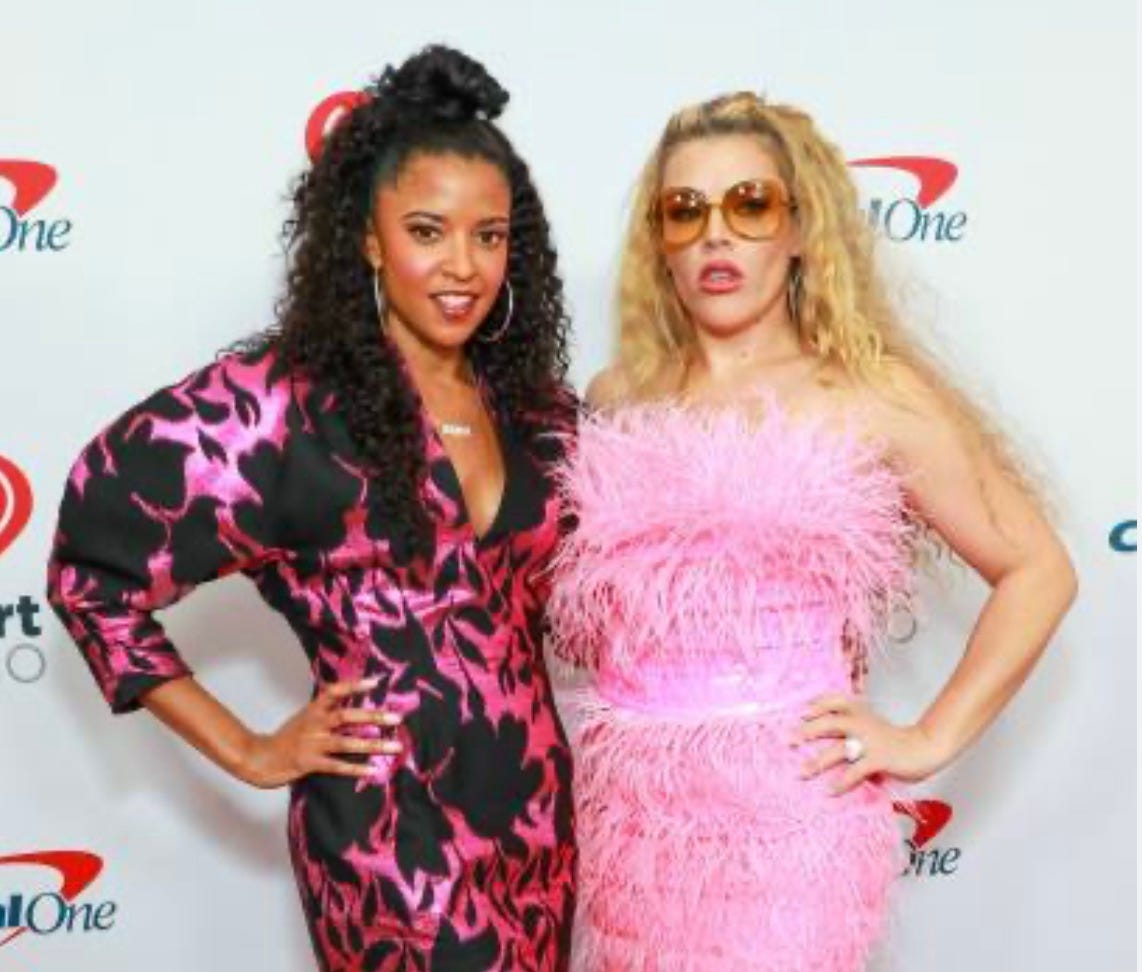 Renée Elise Goldsberry and Busy Philipps as their Girls5Eva characters making a personal appearance at an event