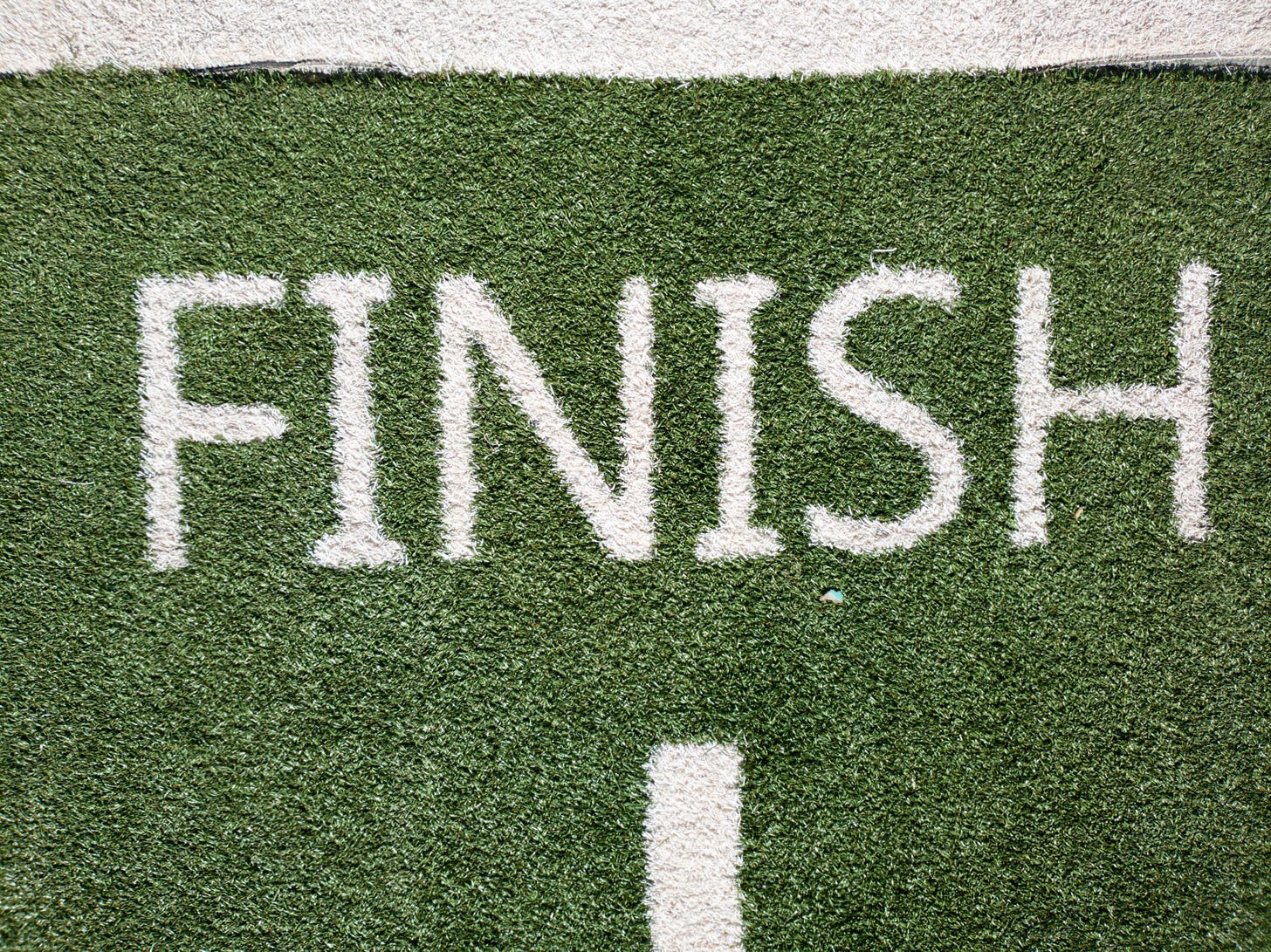 Finish sign painted on grass. Photo by Joshua Hoehne on Unsplash.