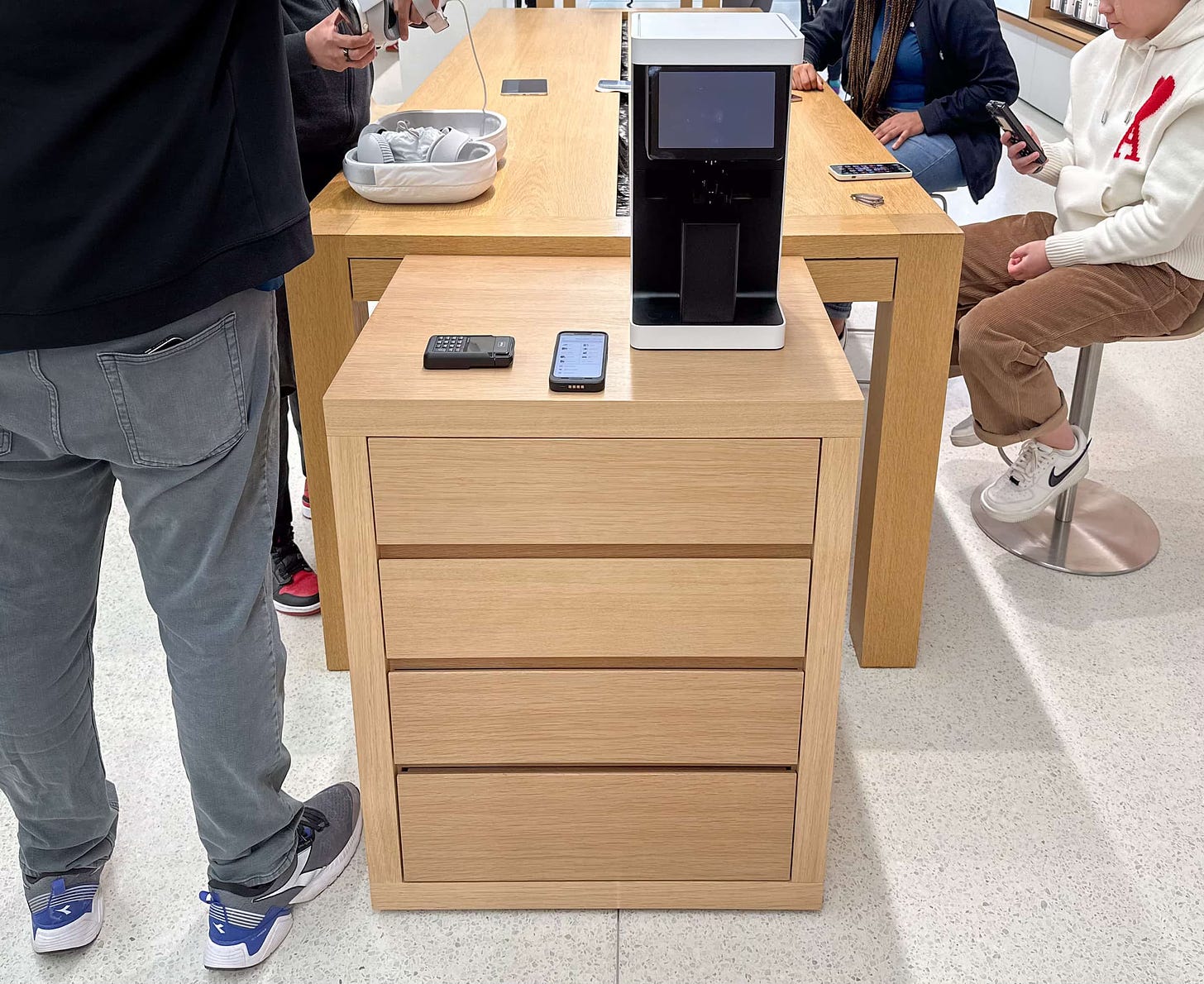 An Apple Vision Pro accessory cabinet and lens scanning machine placed at the end of an Apple Store table.