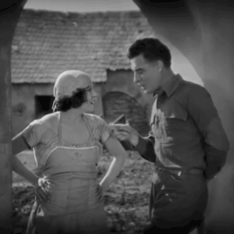 Animated gif from 1925 film The Big Parade - John Gilbert as James Apperson and Renee Adoree as Melisande stand in an archway. Gilbert points at Adoree and himself in turn