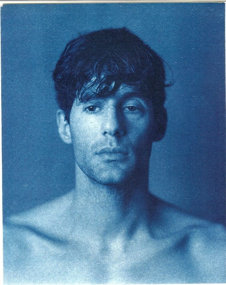 Autoportrait de John Dugdale, photographie cyanotype de lui de face regardant dans le vide.