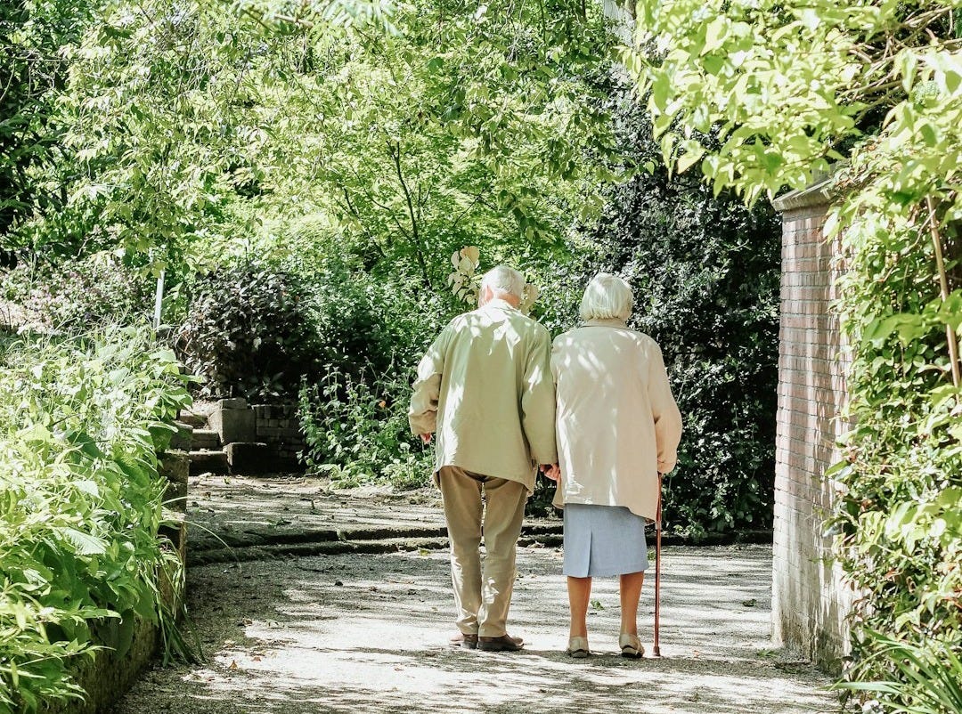 man and woman walking on road during daytime man and woman walking on road during daytime