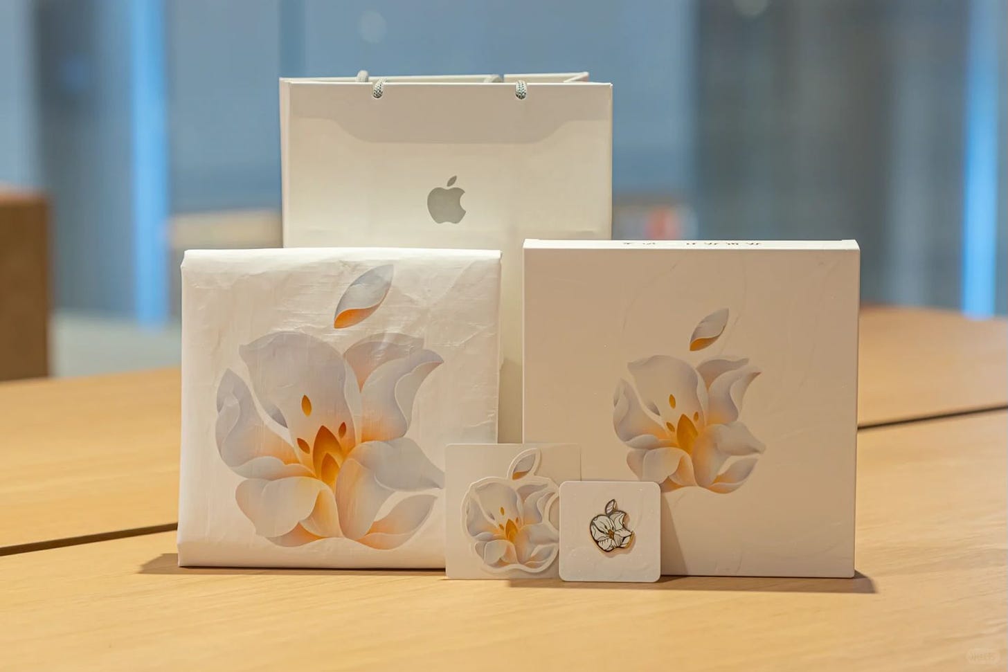 A tote bag and pin featuring the Apple Jing'an logo.