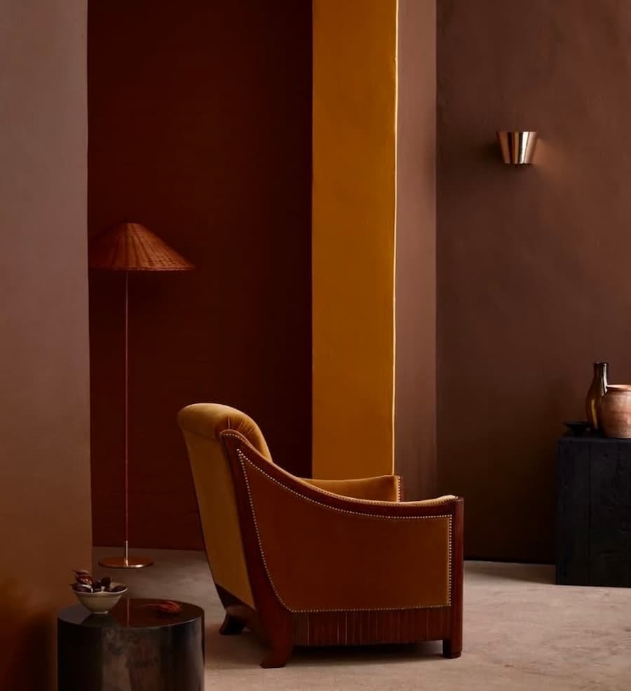 selection of baked earth colours, brown, terracotta, ochre painted on the walls with a chair in the foreground