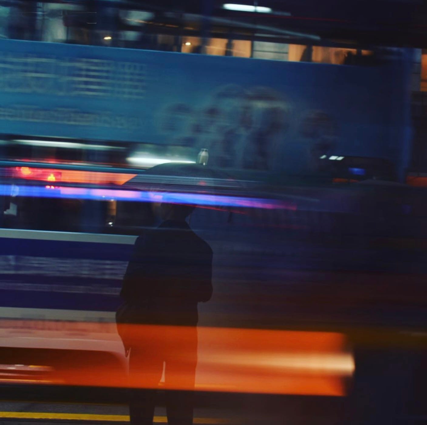 Blurred nighttime photo horizontal lines suggesting motion. Silhouetted person.