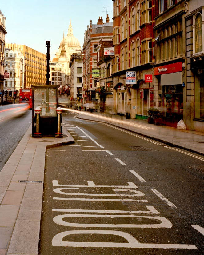 Photo of Ludgate Hill, facing east in the City of London, taken with a long exposure which shows a police watch post in the centre of the road. St. Paul’s cathedral is visible in the distance. White text is overlaid stating “Fifteenth #4: On borders. Available March 15th, 2024 at UXMICHAELCO.SUBSTACK.COM”.