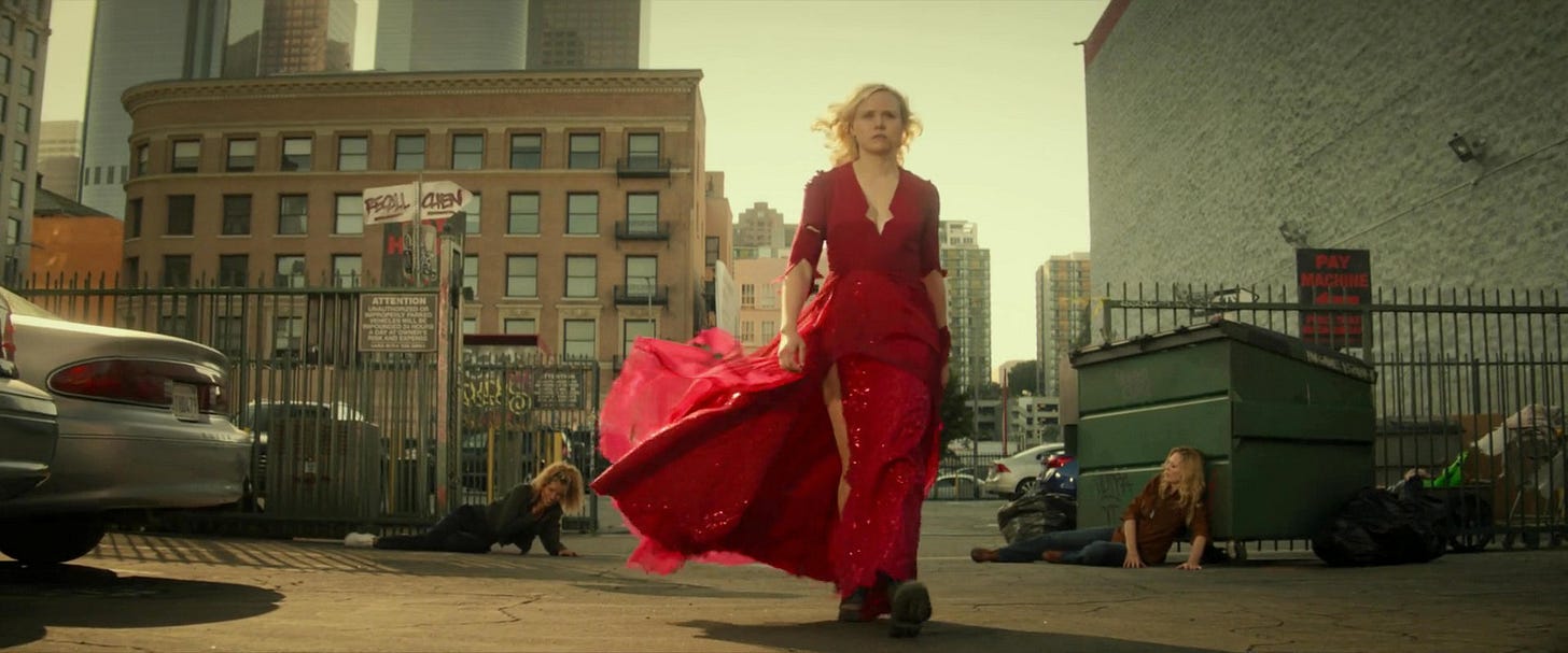 This image shows Agnes Jurati (played by Alison Pill, center) striding away from Raffi Musiker (played by Michelle Hurd, left) and Seven of Nine (played by Jeri Ryan, right) after attacking them in a 2024 Los Angeles parking lot. Raffi and Seven lie gasping on the lot's pavement as Jurati, dressed in a red party dress, walks toward camera. This image shows Agnes Jurati (played by Alison Pill, center) striding away from Raffi Musiker (played by Michelle Hurd, left) and Seven of Nine (played by Jeri Ryan, right) after attacking them in a 2024 Los Angeles parking lot. Raffi and Seven lie gasping on the lot's pavement as Jurati, dressed in a red party dress, walks toward camera.