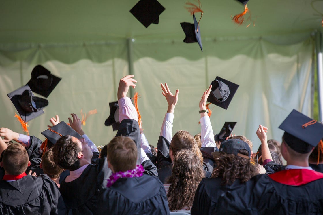 College students throwing their hats in the air at graduation College students throwing their hats in the air at graduation