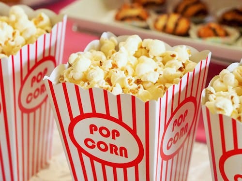 Free Close-up of gourmet popcorn in classic red and white striped boxes, perfect cinema snack. Stock Photo