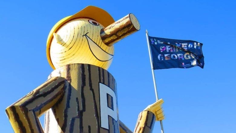 A large faux-wooden lumberjack holds a flag that reads 'Hell Yeah Prince George.'