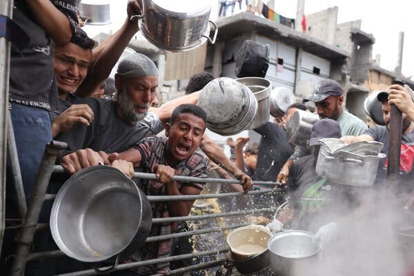 People with desperate expressions struggle to put pots and bowls forward for food handouts. People with desperate expressions struggle to put pots and bowls forward for food handouts.