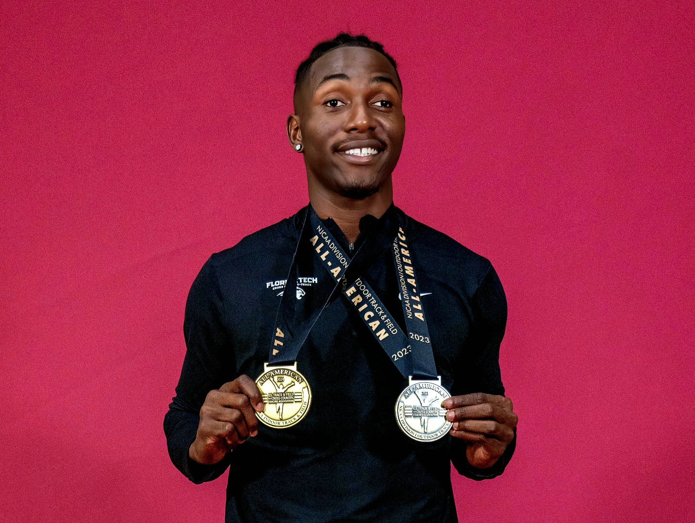 A person holding medals on his chest

Description automatically generated