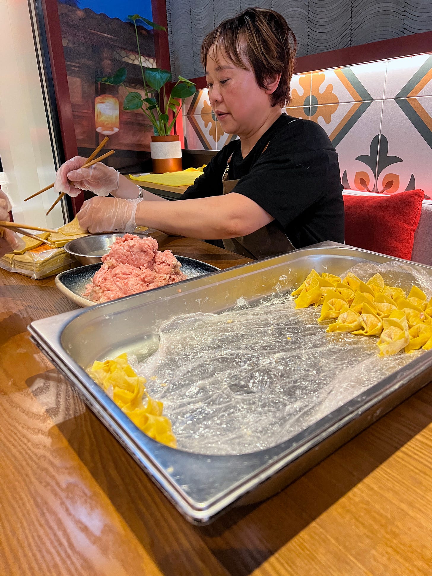 a woman making pork ravioli wontons