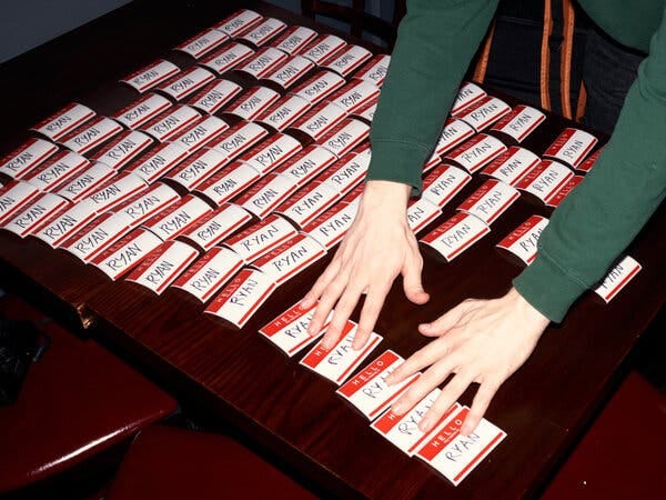 Dozens of red and white name tags that say “Hello, my name is Ryan,” are displayed on a welcome table at the bar Ryan Maguire’s. 