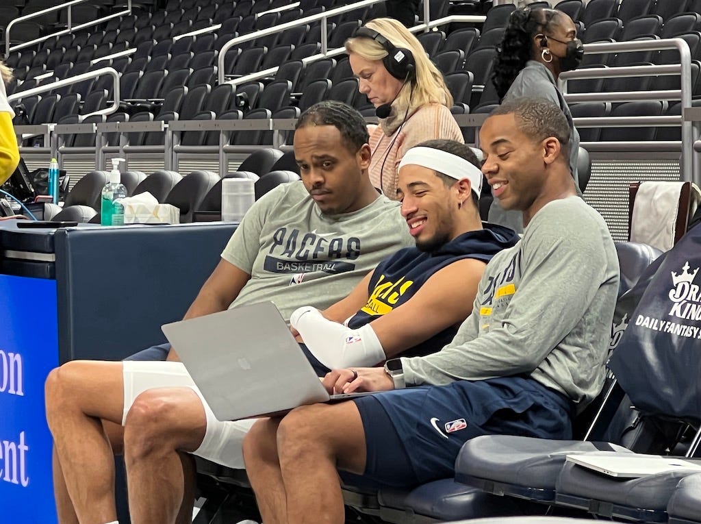 Tyrese Haliburton watching film pregame with video coordinator Isaac Yacob (left) and assistant coach Ronald Nored (right).