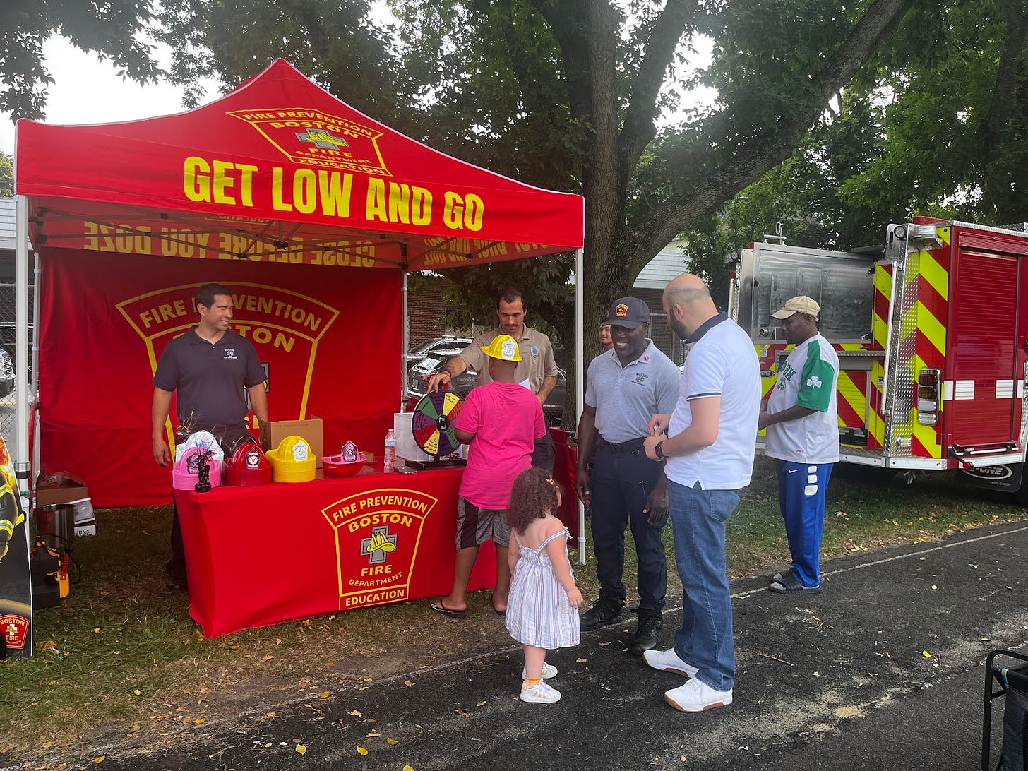 Firefighters speak to community members at the Ready Boston event with a tent that says "Get Low and Go" and the Boston Fire Department logo